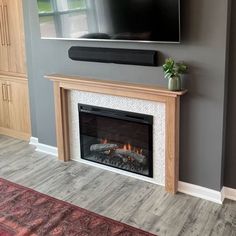 a flat screen tv mounted on the wall above a fireplace