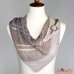 a white mannequin wearing a gray knitted shawl