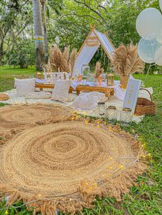 an outdoor picnic with hay rugs and balloons