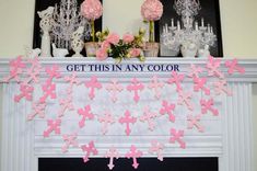 pink and white crosses are hanging on the mantle