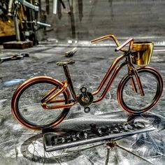 a metal sculpture of a bicycle on top of a table