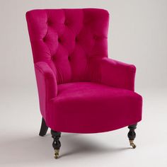 a pink chair sitting in front of a white wall