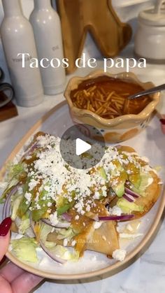 a person is holding a plate with food on it and the words tacos de papaa in front of them