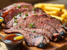 sliced steak and french fries on a cutting board with ketchup, mustard, and sauces