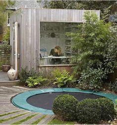 a small house with a garden in front of it and a trampoline on the ground