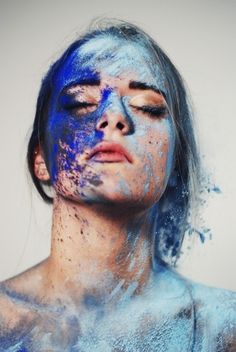 a woman covered in blue powder with her eyes closed and the caption above it