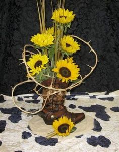 a vase filled with sunflowers sitting on top of a cow print table cloth