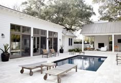 a backyard with a pool and patio furniture