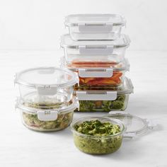 several plastic containers filled with food on top of a white counter next to each other