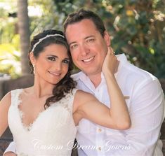 a man and woman sitting on a bench posing for the camera with their arms around each other