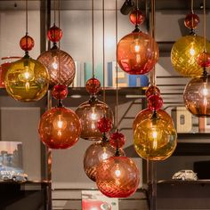 many different colored glass balls hanging from the ceiling