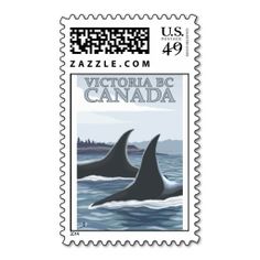 a postage stamp with two orca whales swimming in the water and trees in the background