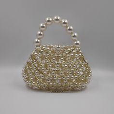 Introducing the stunning rhinestone pearl bag, meticulously handcrafted with love and passion by an Indian artisan using premium faux pearls. This show-stopping bag is destined to capture all eyes. More than just a stylish accessory, the micromini bag is a perfect gift for a myriad of occasions - birthdays, Valentine's Day, anniversaries, Mother's Day, engagements, festivals, and beyond. Unparalleled in versatility, the statement bag is tailored to various settings. Whether it's a nightclub part Gold Pearl Clutch For Parties, Party Gold Pearl Clutch, Gold Pearl Party Clutch, Elegant Bags With Pearl Chain For Gift, Glamorous Handheld Evening Bag With Pearl Handle, Gold Clutch With Pearl Embroidery, Gold Pearl Clutch With Pearl Embroidery, Elegant Party Bag With Pearl Chain, Glamorous Pearl Clutch With Pearl Handle