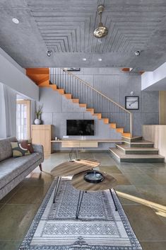 an open living room with stairs leading up to the second floor