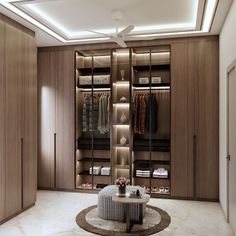 a large walk - in closet with clothes and shoes on the shelves, along with a round coffee table