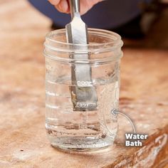 a person using a knife to cut something in a jar