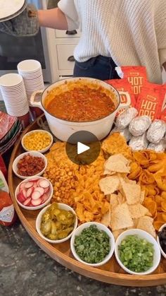 a platter filled with chips, salsa and other condiments