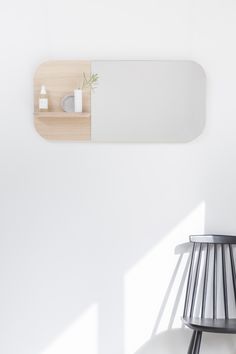 a white wall with a mirror and shelf on it