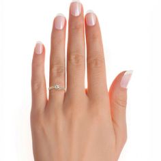 a woman's hand with white nails and a ring on her left hand, against a white background