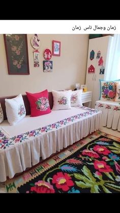 a bed with many pillows on top of it and a rug in front of it