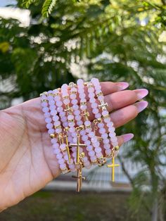 Pink beaded protection bracelets with gold accents and cross charm. ✨