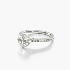 a white gold engagement ring with a pear shaped diamond in the center and side stones