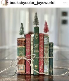 a stack of books with christmas trees sitting on top of each book, and the caption reads books by color / jaysword