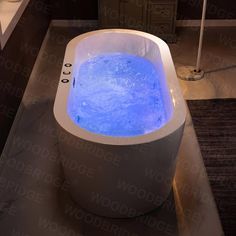 a bath tub with blue water inside of it on a counter top next to a sink