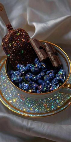 a cup filled with blue and gold candy