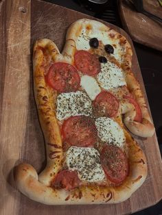 a pizza with tomatoes, cheese and olives on it