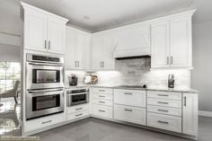 a kitchen with white cabinets and stainless steel appliances