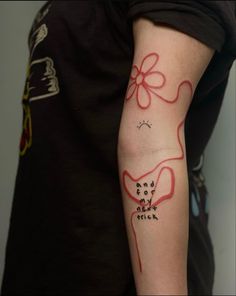 a person with a tattoo on their arm that has words and a flower in it