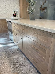 a kitchen with marble counter tops and wooden cabinets