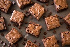 chocolate brownies with chocolate chips scattered around them on a baking sheet, ready to be eaten