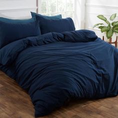 a bed with blue sheets and pillows in a room