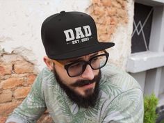 "This listing is for a Dad Est hat. The Dad Cap is a staple in any outfit, your dad can dress up or down. This unstructured cap allows effortless style and comfort. DETAILS: ➤ One size fits all hat with a custom embroidered design. ➤ Dad caps have a curved visor and a buckle strap closure with grommet. ➤ Snapback hats have a flat visor and snapback closure for easy sizing. ➤ Hats come in four colors: Black, Dark Grey, Navy, and White. ➤ Printed, Packaged and Shipped From The USA. Support a local Psytrance Clothing, Embroidered Beanies, Festival Outfits Men, Rave Edm, Drum N Bass, Japanese Logo, Rave Music, Flat Bill Hats, Comfy Sweatpants