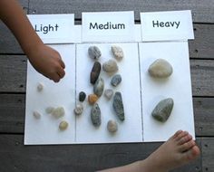 two children are holding rocks and pointing them at them with their feet on the ground