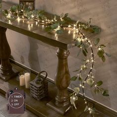 a table with candles and greenery on it, next to a mirror that says 1 timer 2 on 3 off