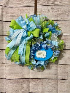 a blue and green wreath hanging on the side of a wooden wall with a sign that says, for you