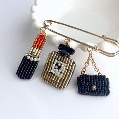 three pieces of beaded jewelry are hanging from a metal hook on a white plate