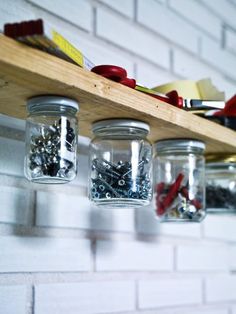 mason jars filled with screws and nails on a shelf