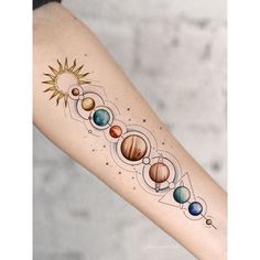 a woman's arm with the solar system tattoo on her left forearm, and eight planets around it