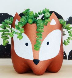 a planter with a fox face painted on it