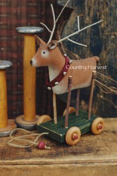 a wooden toy horse pulling a sleigh with wood spools on it