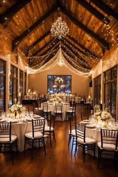 a room filled with lots of tables covered in white clothed cloths and decorated centerpieces