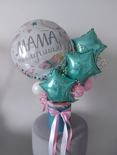 some balloons are sitting on top of a cake with the words mam in my name written on it