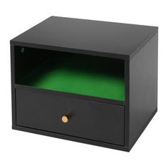 a black box with green paper in it on a white background and the bottom drawer is open