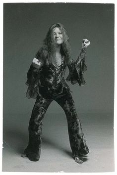 an old black and white photo of a woman with long hair holding her arms in the air