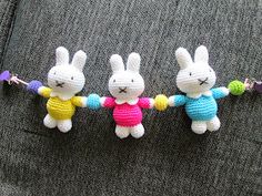 three crocheted bunnies are holding hands