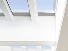 an open door leading into a room with skylights on the ceiling and white walls